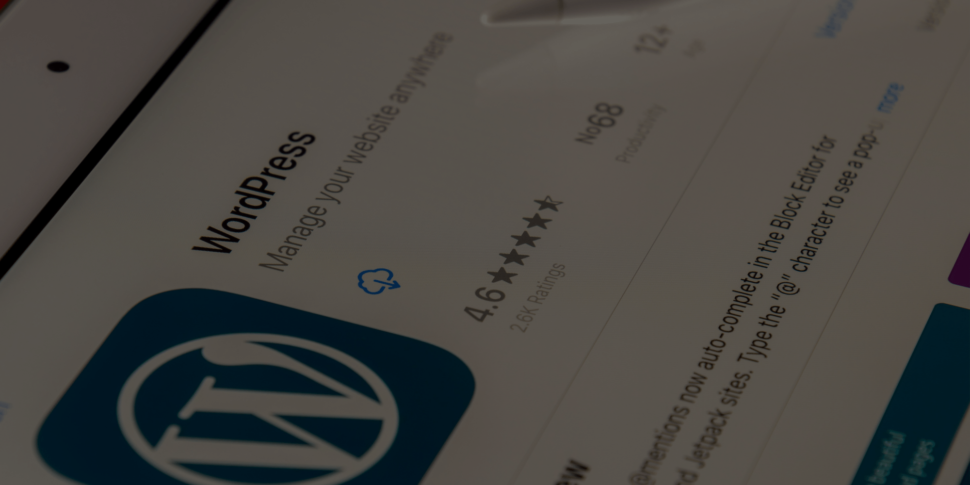 Close-up of a tablet screen displaying the WordPress app page with a 4.6-star rating and app details.